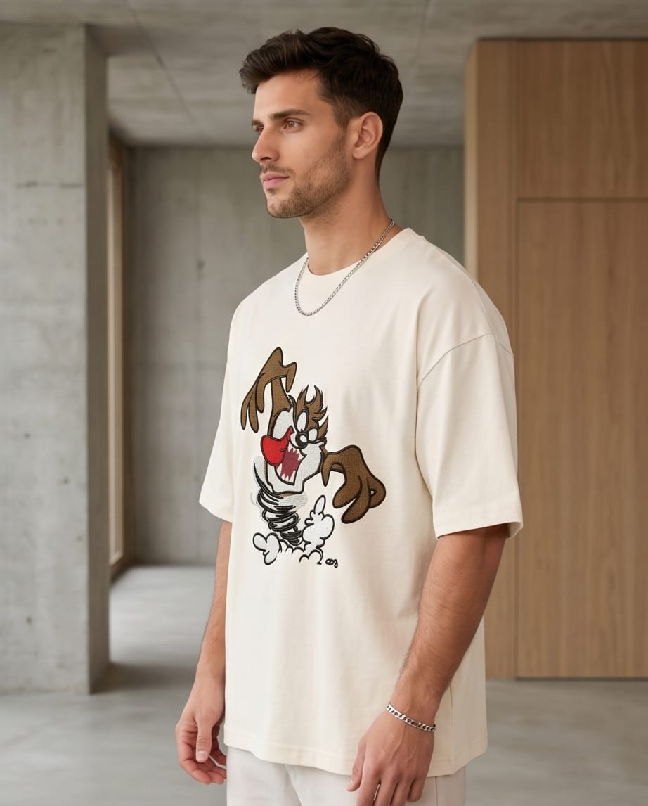 E-commerce product photo of a premium off-white streetwear t-shirt with custom character embroidery and a relaxed, drop-shoulder fit.