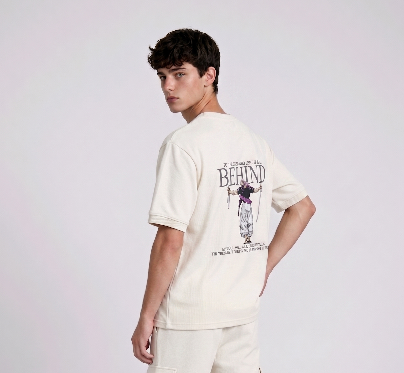 A male model from the back, wearing a black oversized t-shirt with a large, detailed embroidery design.
