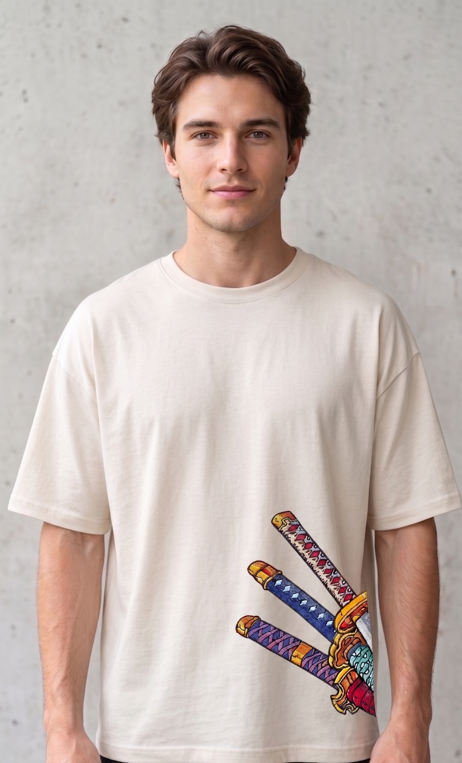 A male model wearing a premium off-white oversized t-shirt featuring three detailed katana hilts in high-density direct embroidery on the lower side