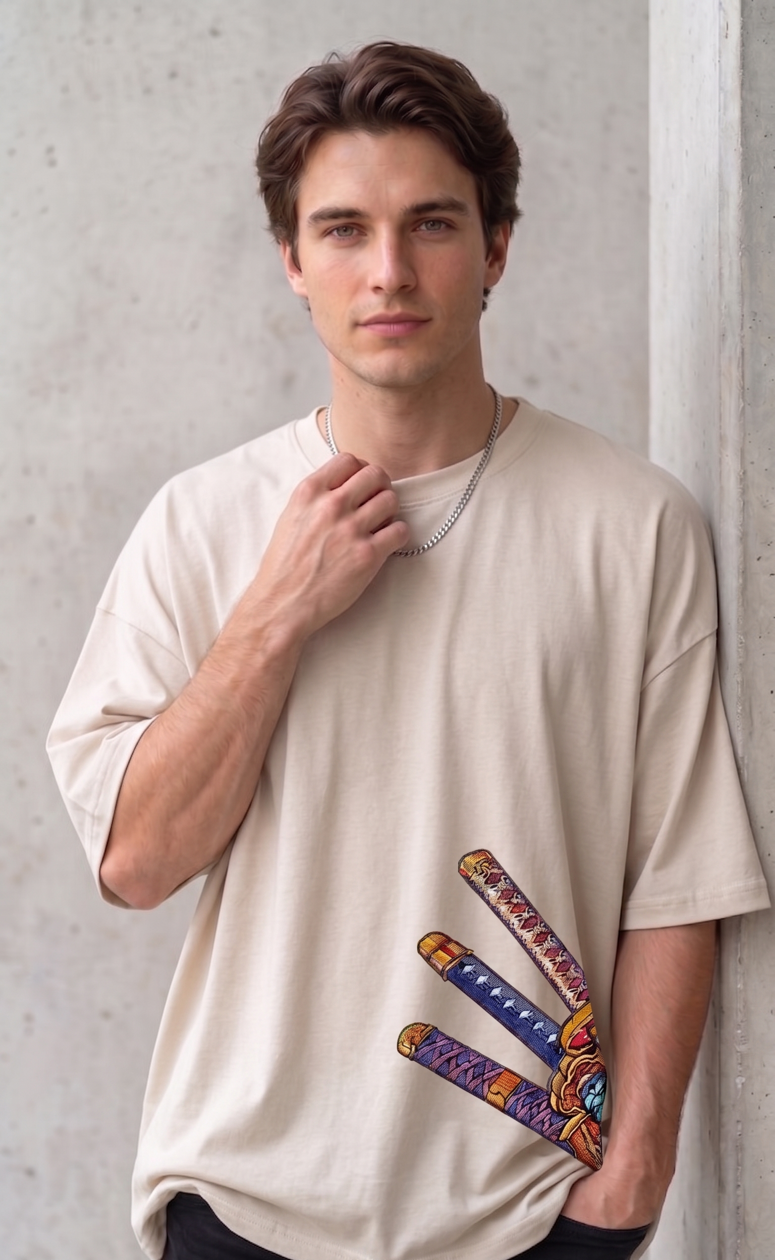 A male model wearing a premium off-white oversized t-shirt featuring three detailed katana hilts in high-density direct embroidery on the lower side