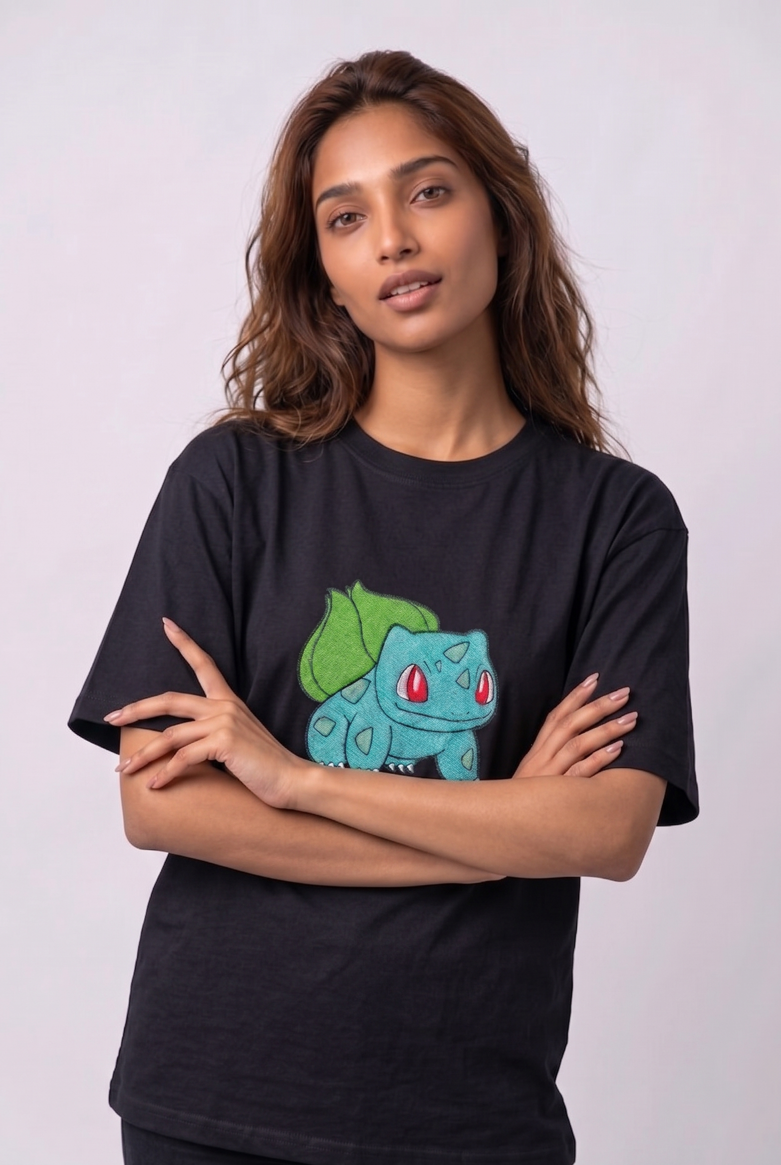 A female model wearing an Black oversized t-shirt featuring a detailed green and blue Bulbasaur character embroidered in the center of the chest.