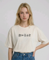 wearing an oversized, half-sleeved heavyweight cotton t-shirt. The chest features high-density direct embroidery of five minimalist coffee-themed icons in a horizontal row, including a French press, coffee beans, a coffee bag, a steaming cup, and a moka pot.
