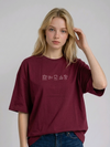 wearing an oversized, half-sleeved heavyweight cotton t-shirt. The chest features high-density direct embroidery of five minimalist coffee-themed icons in a horizontal row, including a French press, coffee beans, a coffee bag, a steaming cup, and a moka pot.
