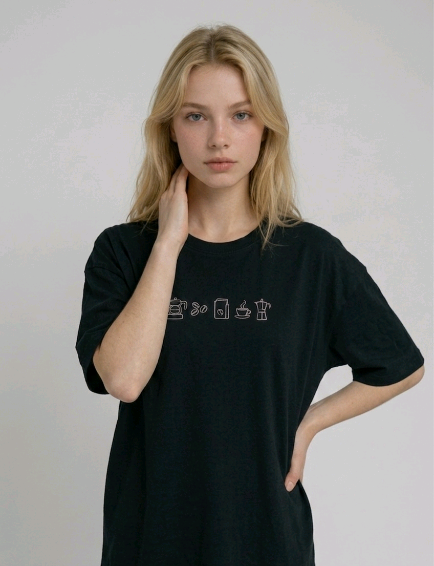 wearing an oversized, half-sleeved heavyweight cotton t-shirt. The chest features high-density direct embroidery of five minimalist coffee-themed icons in a horizontal row, including a French press, coffee beans, a coffee bag, a steaming cup, and a moka pot.

