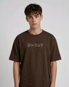 wearing an oversized, half-sleeved heavyweight cotton t-shirt. The chest features high-density direct embroidery of five minimalist coffee-themed icons in a horizontal row, including a French press, coffee beans, a coffee bag, a steaming cup, and a moka pot.
