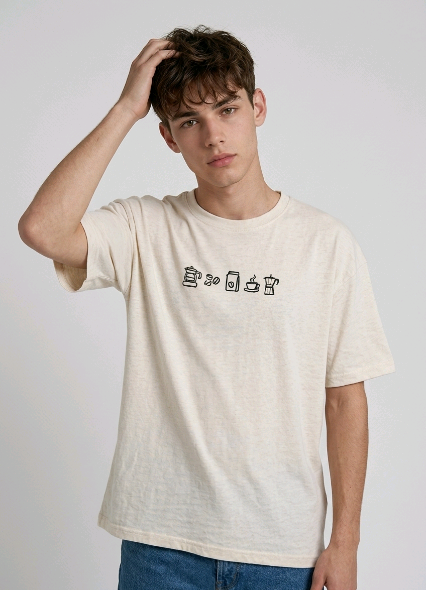 wearing an oversized, half-sleeved heavyweight cotton t-shirt. The chest features high-density direct embroidery of five minimalist coffee-themed icons in a horizontal row, including a French press, coffee beans, a coffee bag, a steaming cup, and a moka pot.
