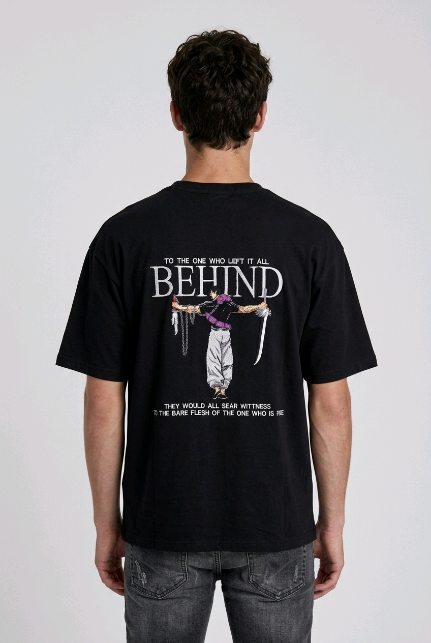 A male model from the back, wearing a black oversized t-shirt with a large, detailed embroidery design.
