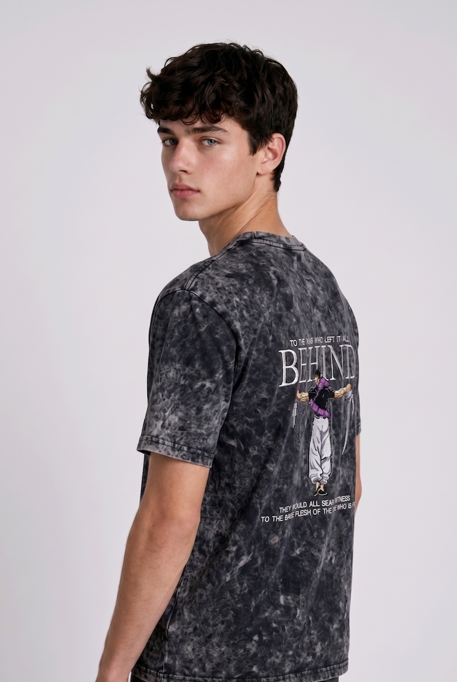 A male model from the back, wearing a Acid wash oversized t-shirt with a large, detailed embroidery design.
