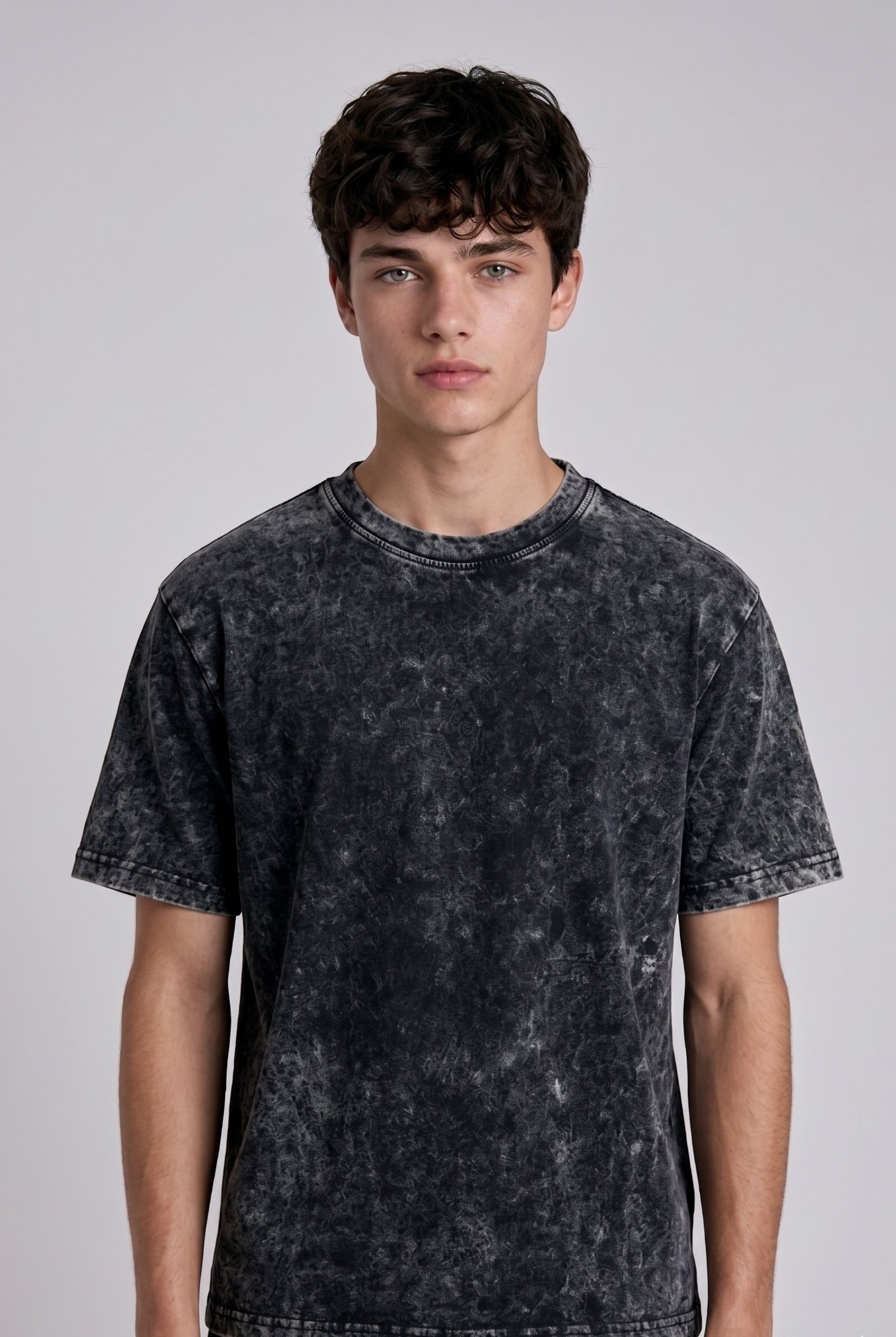 A male model from the back, wearing a Acid wash oversized t-shirt with a large, detailed embroidery design.
