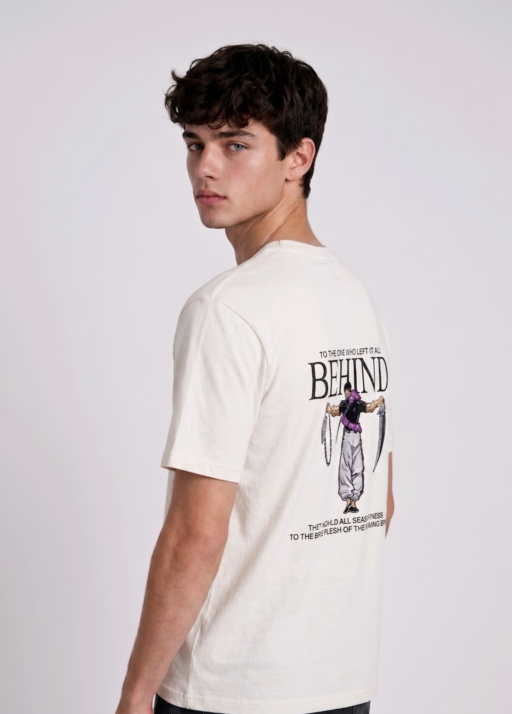A male model from the back, wearing a black oversized t-shirt with a large, detailed embroidery design.
