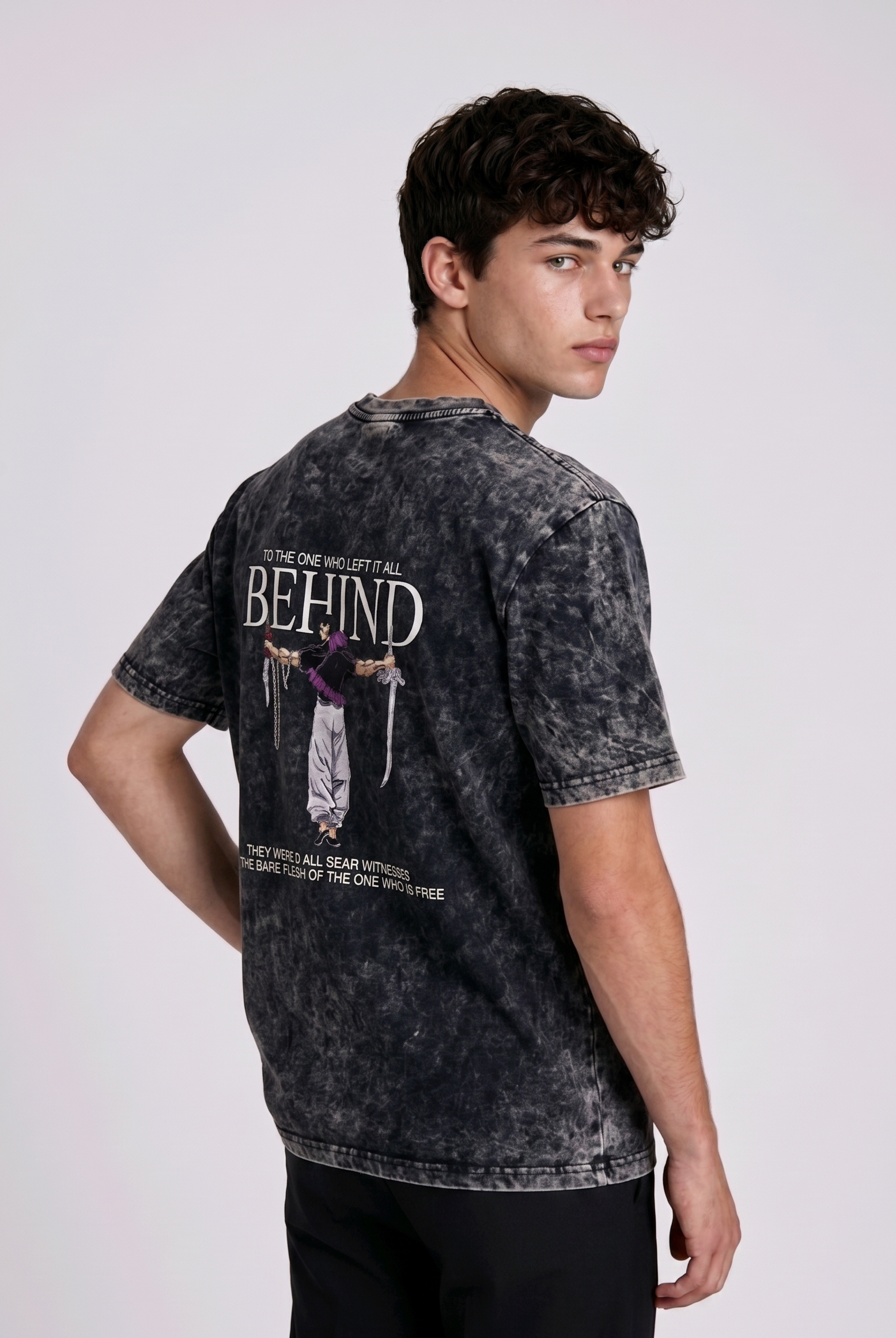 A male model from the back, wearing a Acid wash oversized t-shirt with a large, detailed embroidery design.
