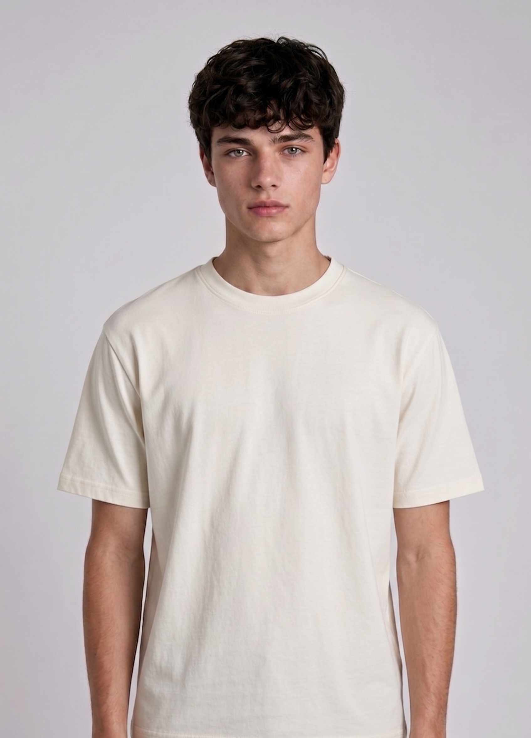 A male model from the back, wearing a black oversized t-shirt with a large, detailed embroidery design.
