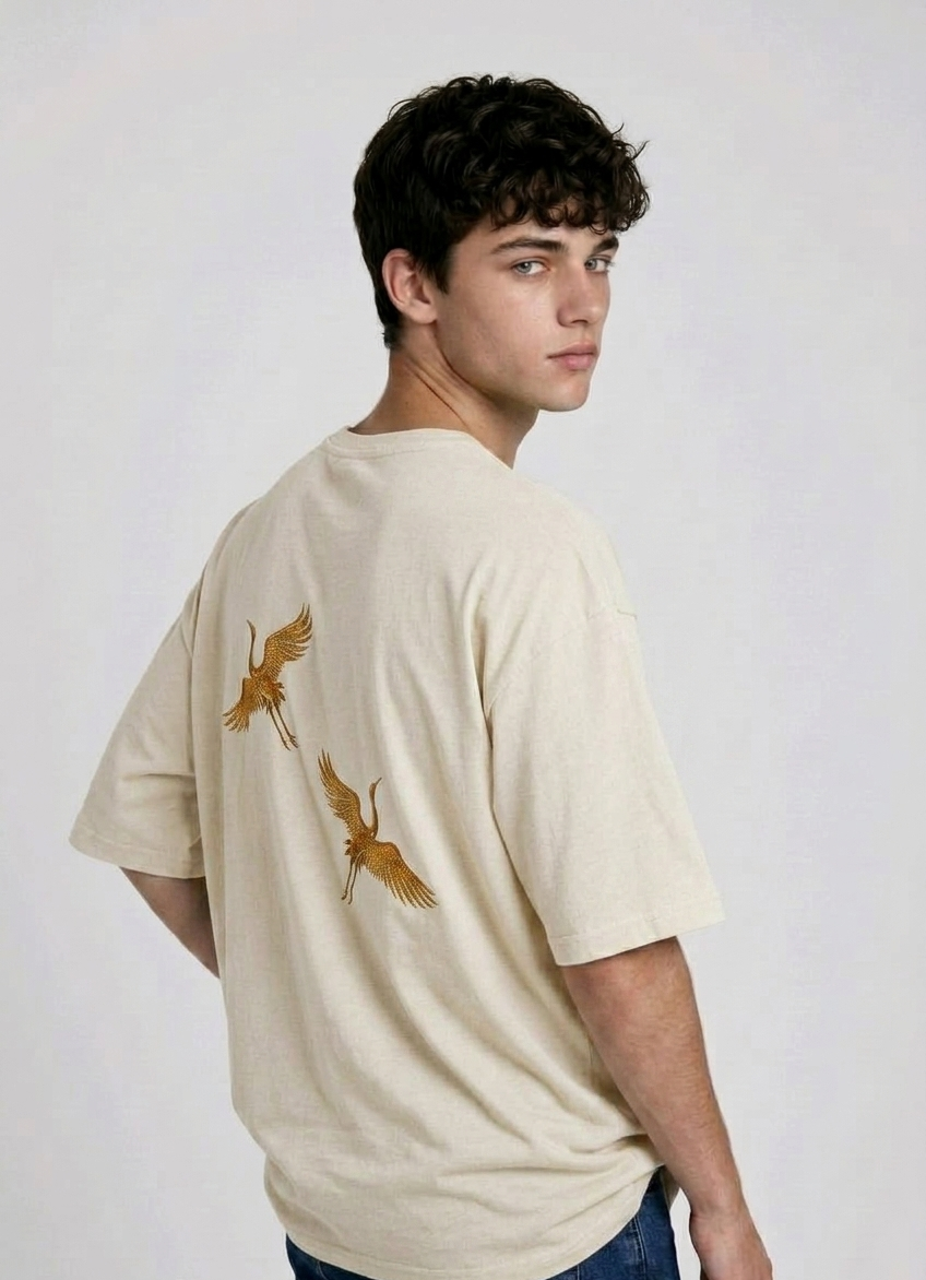 Rear view of a person wearing a heavyweight oversized half-sleeved t-shirt featuring high-density direct embroidery of two golden cranes on the back.

