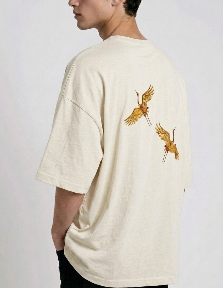 Rear view of a person wearing a heavyweight oversized half-sleeved t-shirt featuring high-density direct embroidery of two golden cranes on the back.

