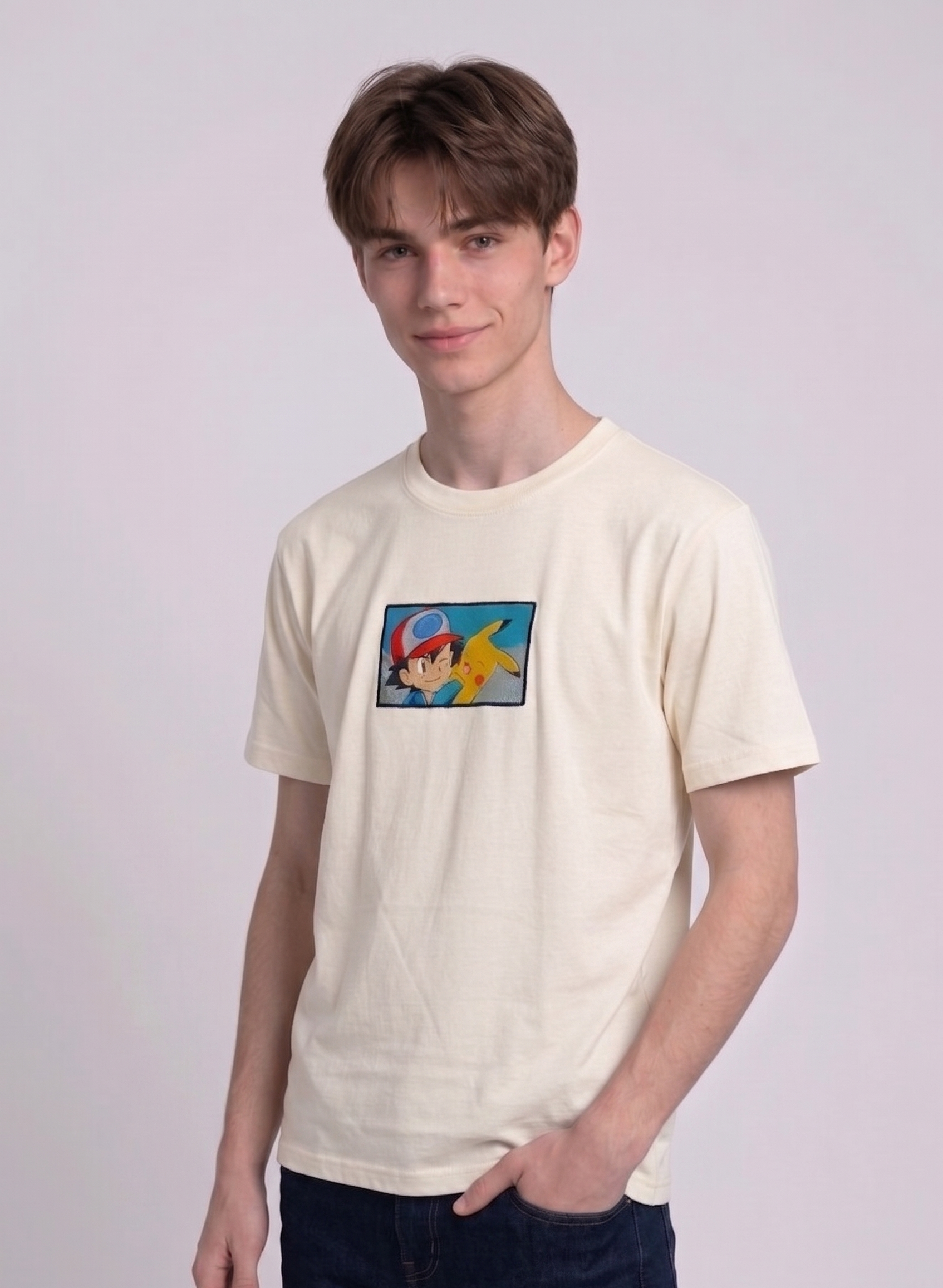 He is wearing  heavyweight cotton t-shirt with a detailed, colorful embroidered patch on the chest featuring anime characters Ash Ketchum (winking) and Pikachu.