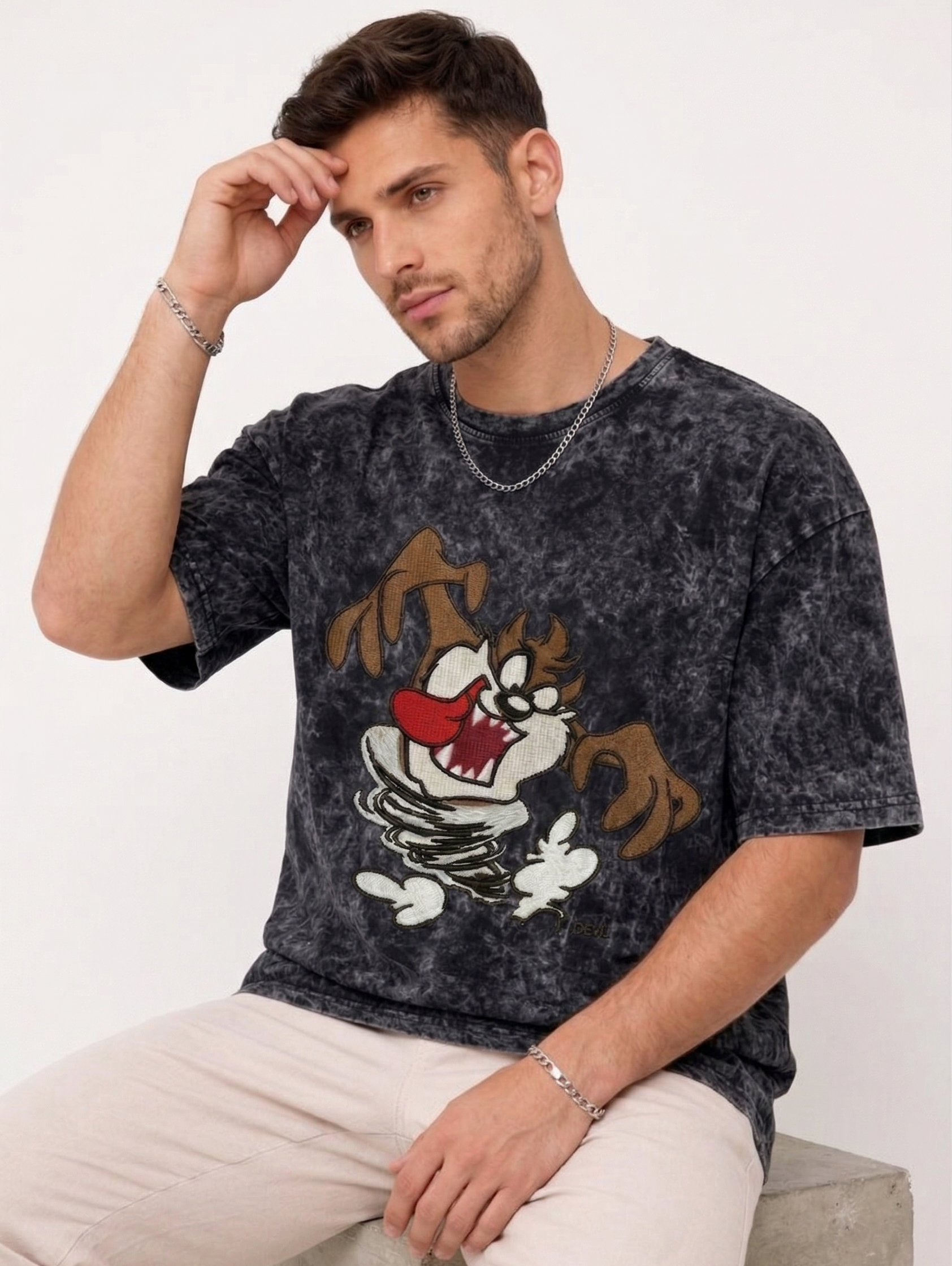 E-commerce product photo of a premium acid-wash streetwear t-shirt with custom character embroidery and a relaxed, oversized fit.