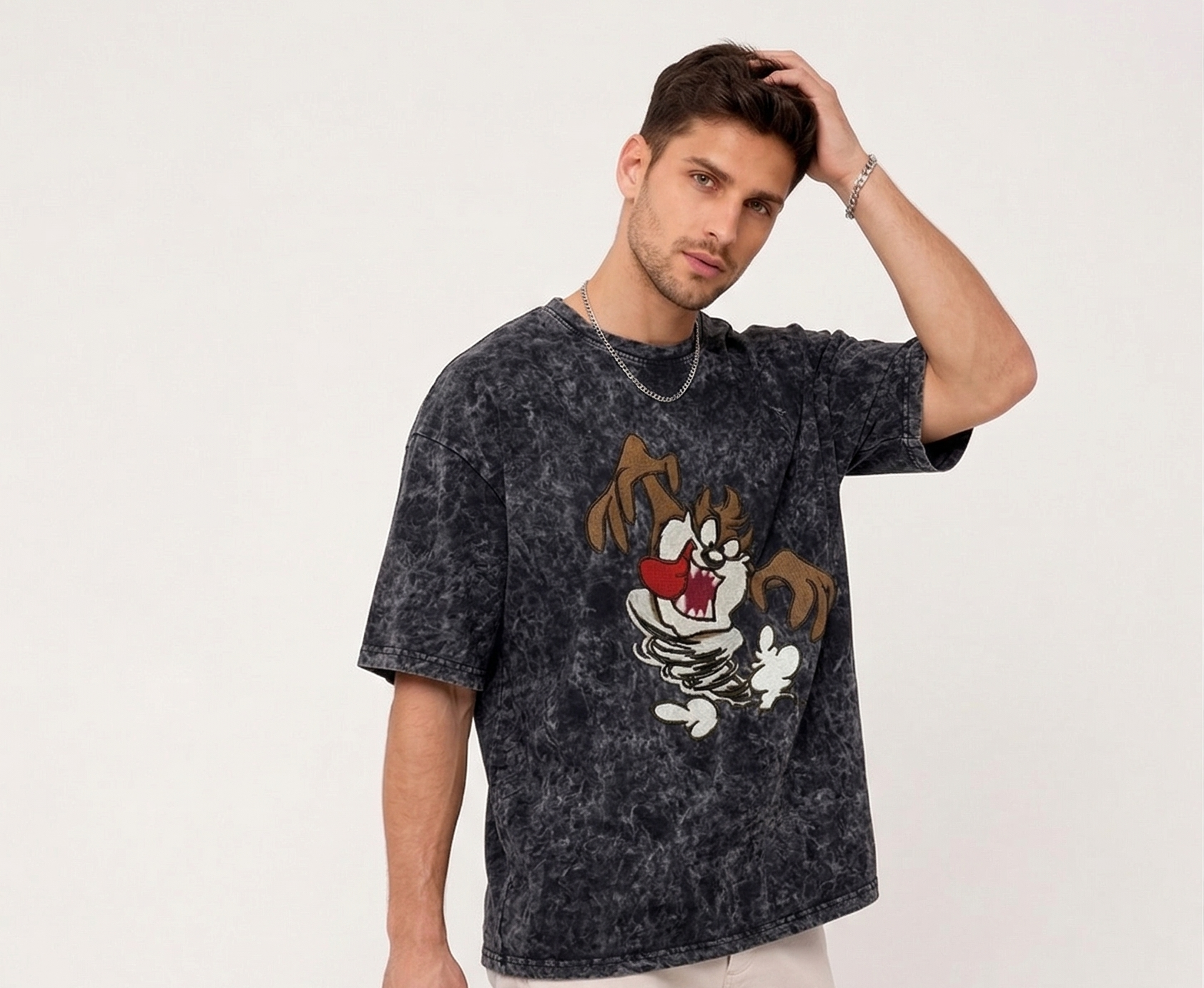E-commerce product photo of a premium acid-wash streetwear t-shirt with custom character embroidery and a relaxed, oversized fit.