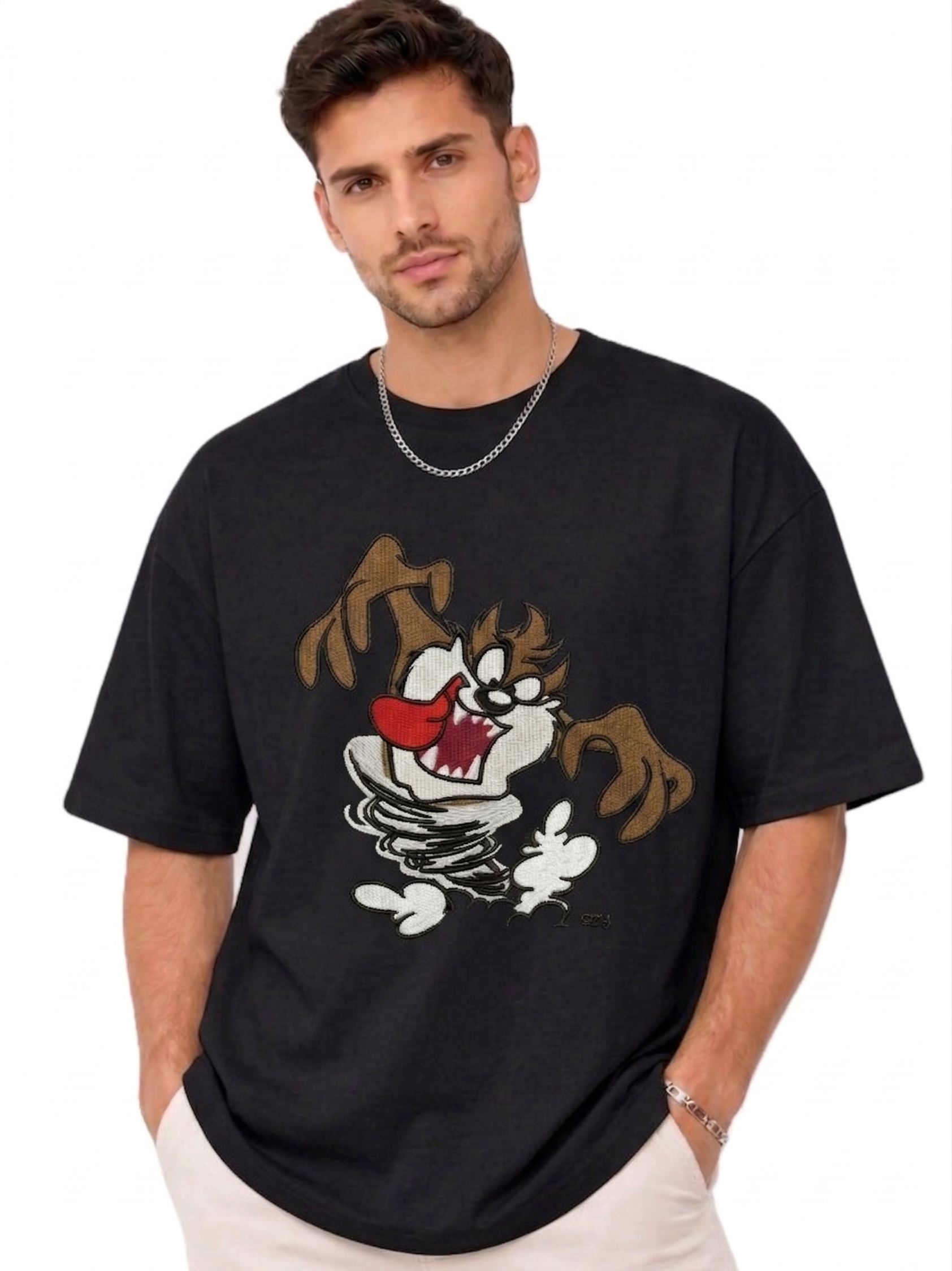 E-commerce product photo of a premium black streetwear t-shirt with custom character embroidery and a relaxed, oversized silhouette.