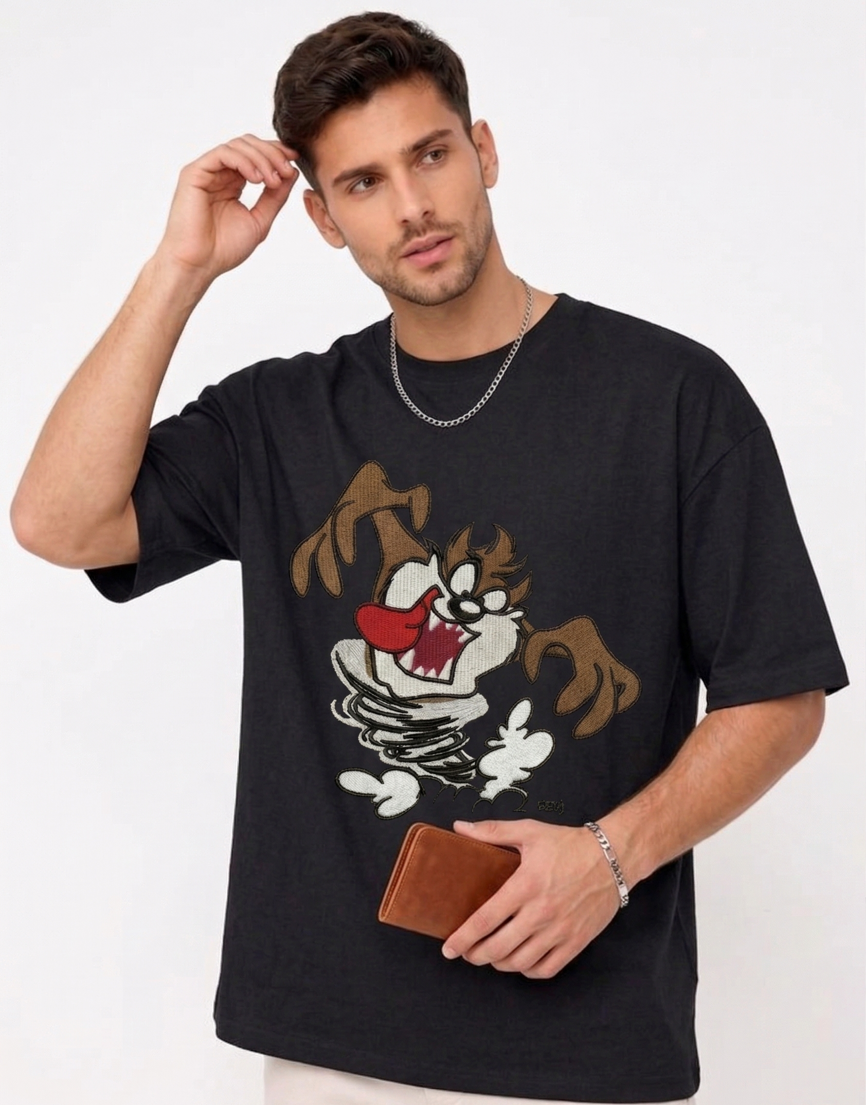 E-commerce product photo of a premium black streetwear t-shirt with custom character embroidery and a relaxed, oversized silhouette.