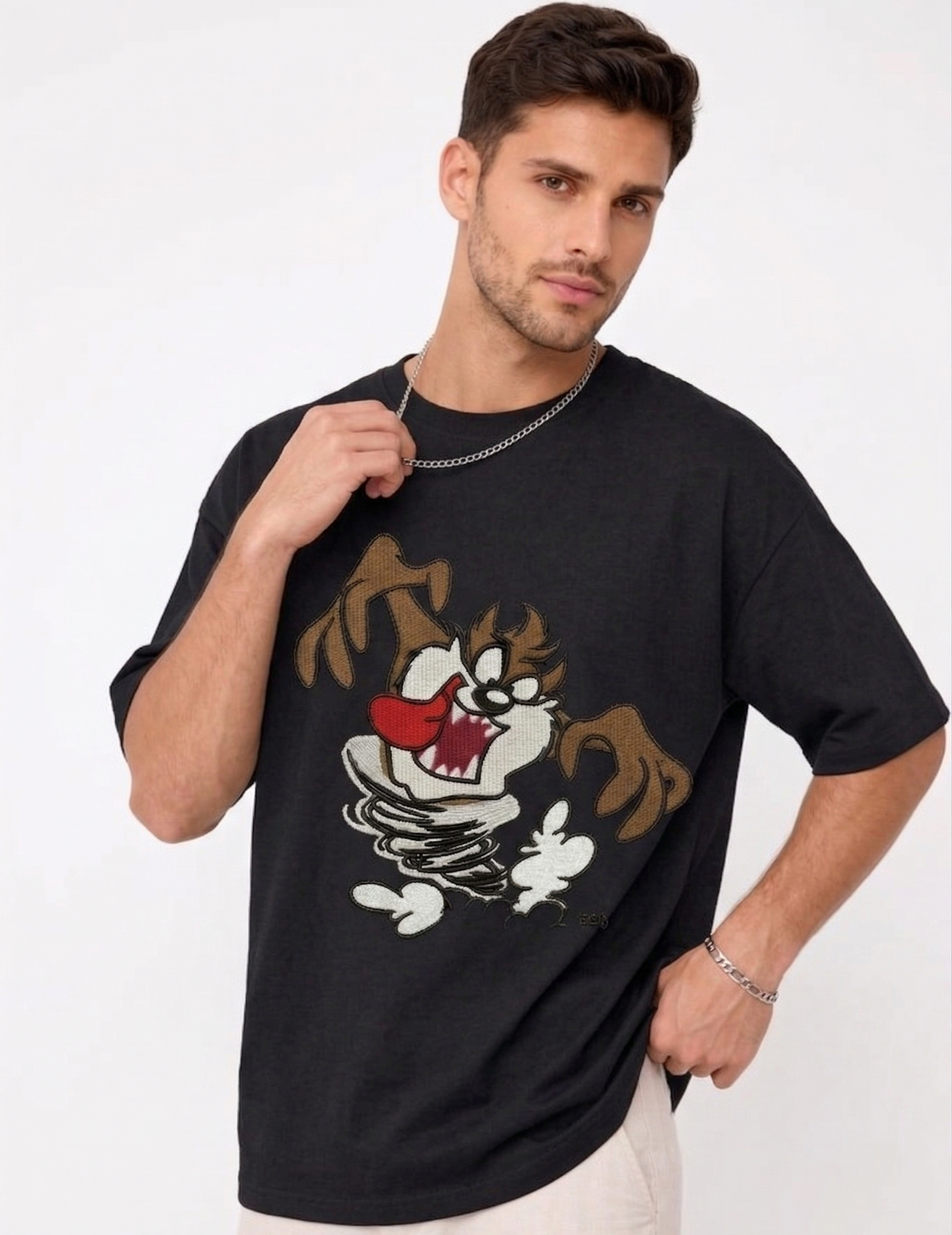 E-commerce product photo of a premium black streetwear t-shirt with custom character embroidery and a relaxed, oversized silhouette.