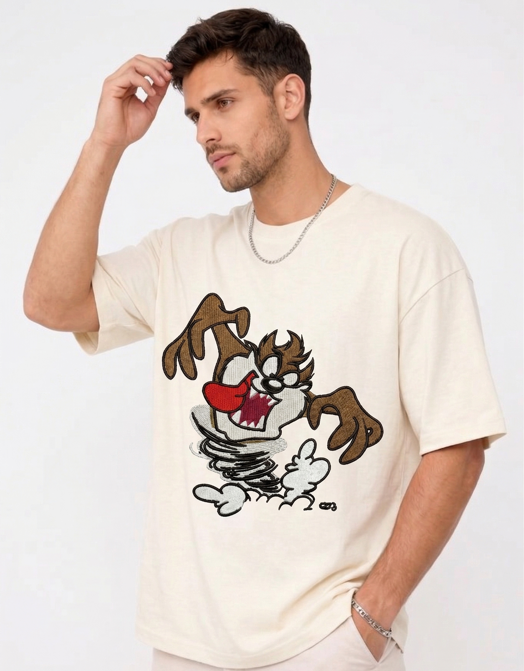 
E-commerce product photo of a premium off-white streetwear t-shirt with custom character embroidery and a relaxed, drop-shoulder fit.