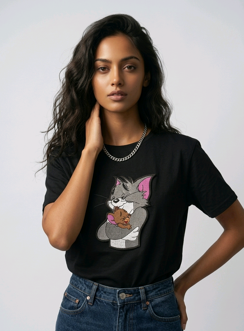 E-commerce product shot of a black streetwear t-shirt with custom character embroidery and a silver chain necklace accessory.