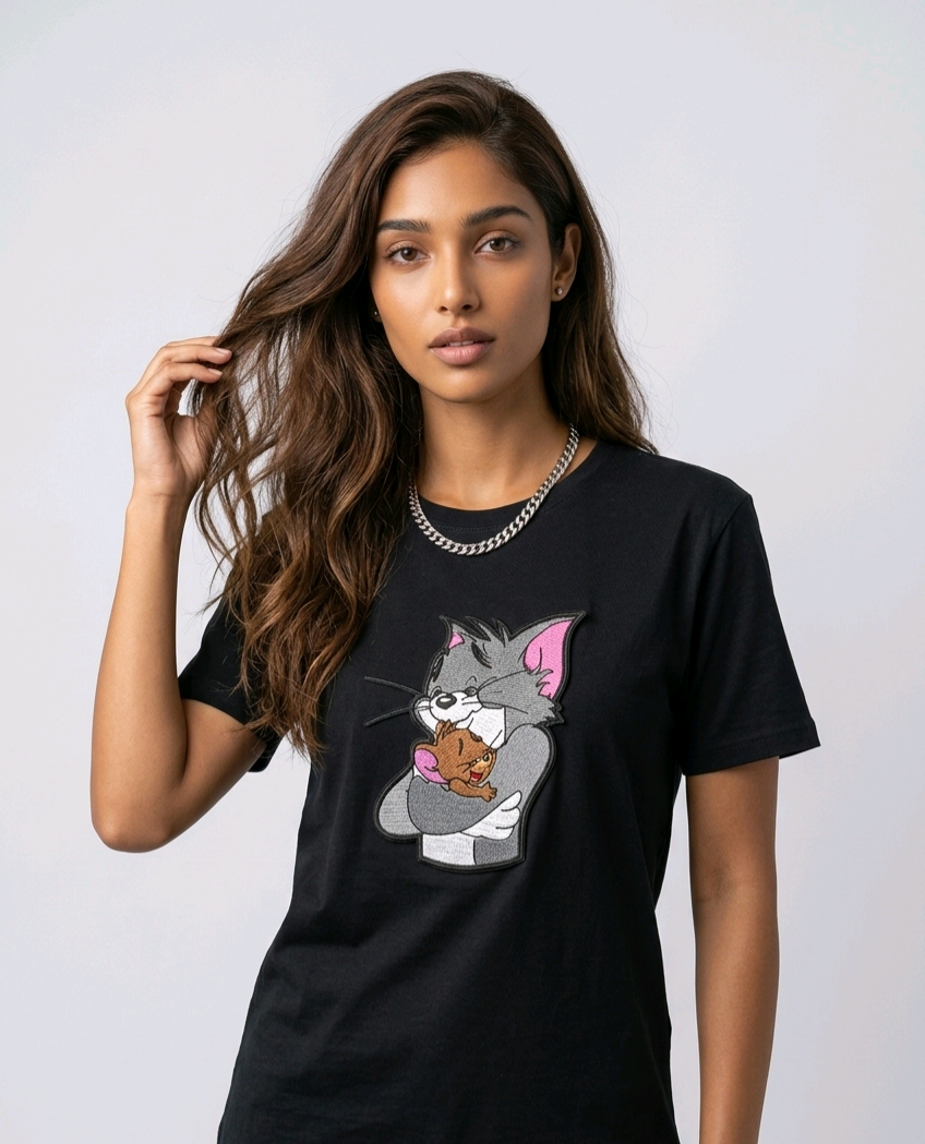 E-commerce product shot of a black streetwear t-shirt with custom character embroidery and a silver chain necklace accessory.